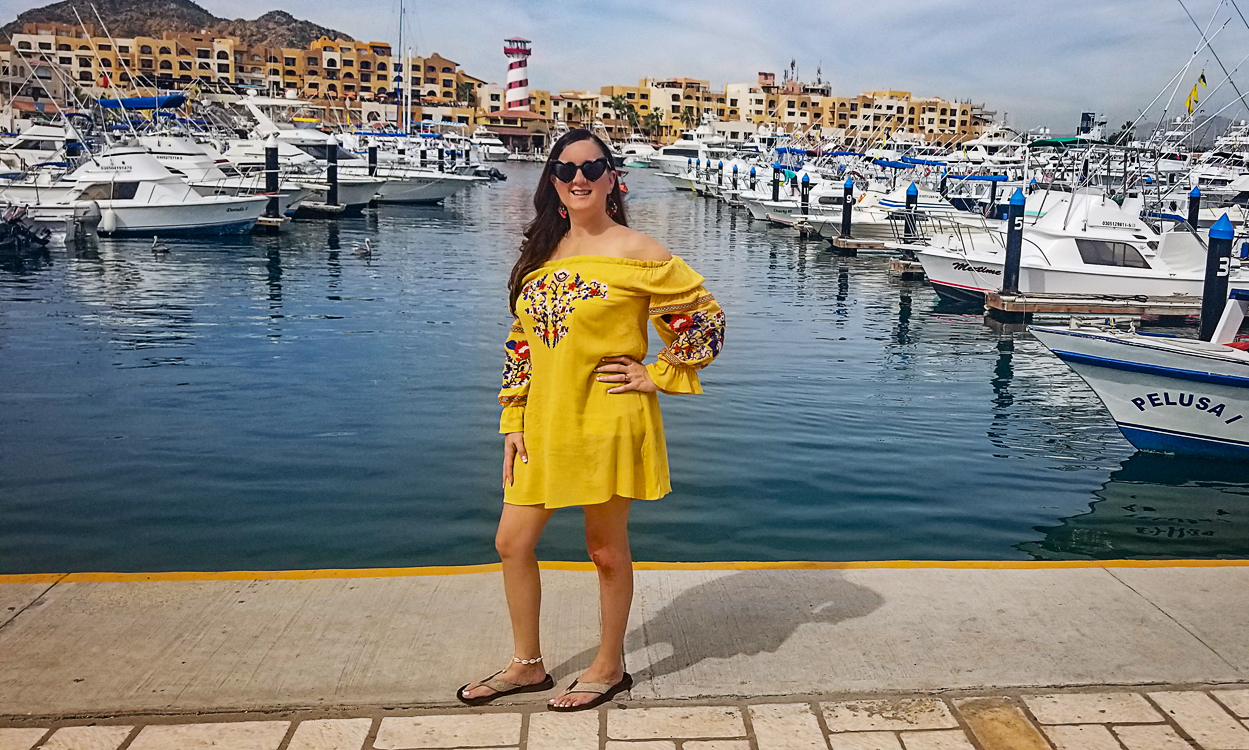 Wearing a yellow dress at the marina in Cabo San Lucas